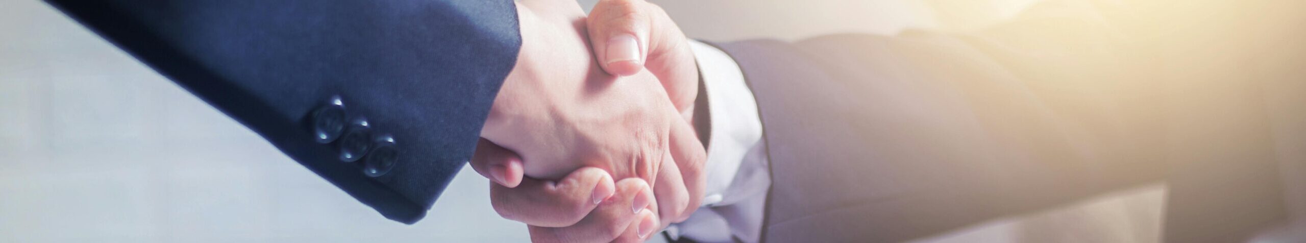 Professional handshake agreement over business charts in an office setting.